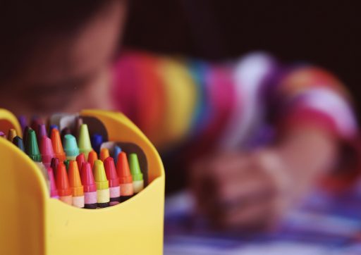 selective focal photo of crayons in yellow box