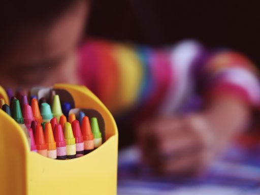 selective focal photo of crayons in yellow box