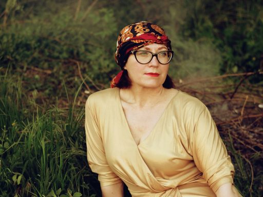 woman in brown long sleeve shirt wearing black and brown floral bandana