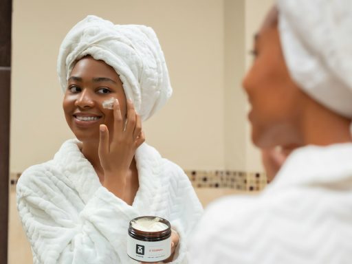 a woman with a towel on her head and a jar of cream on her face