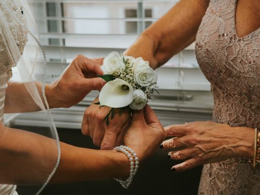 woman put white flowers on woman's hand