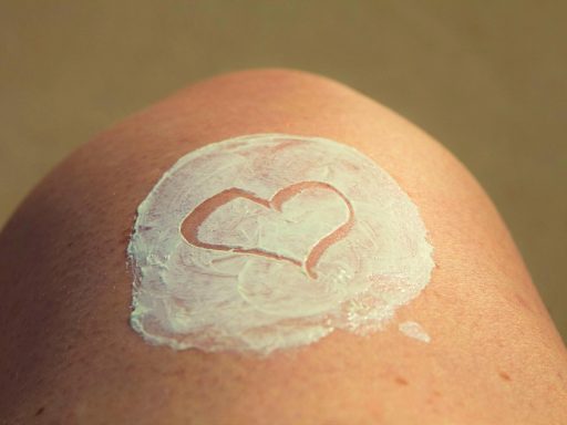 Vrouw die zonnebrand aanbrengt op haar gezicht tijdens zomerhitte