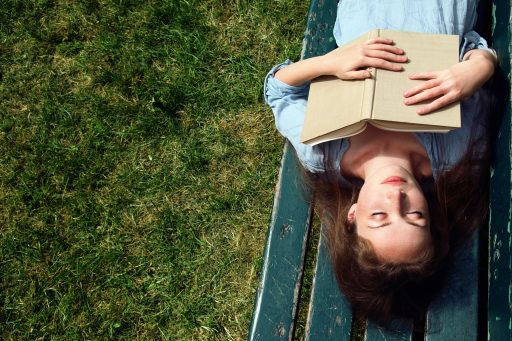 Vrouw zit ontspannen buiten in de tuin op een zomerse dag