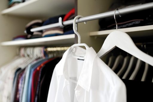 Vrouw die haar kledingkast organiseert en kleding sorteert voor een bewustere garderobe