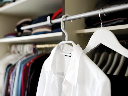 Vrouw die haar kledingkast organiseert en kleding sorteert voor een bewustere garderobe