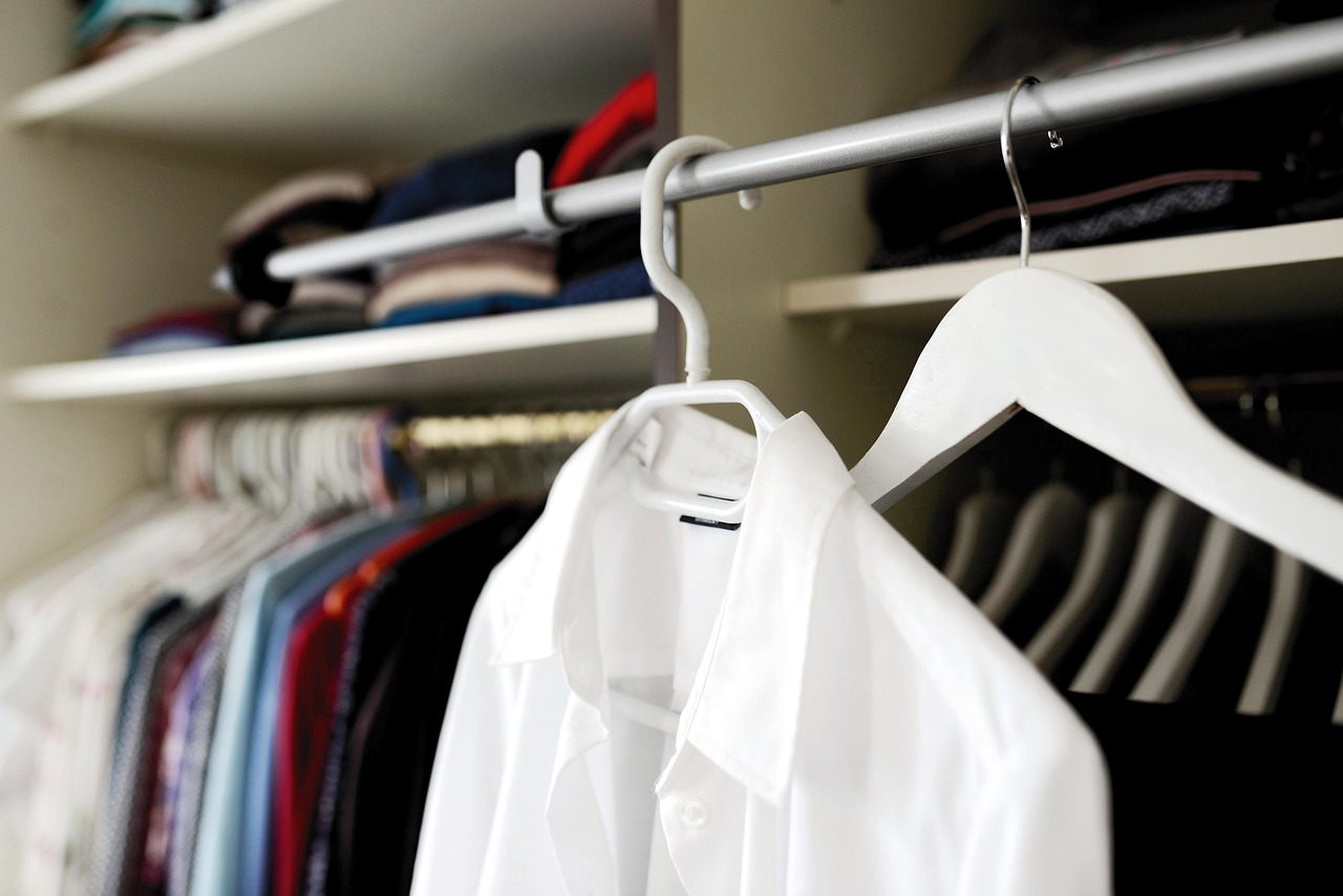 Vrouw die haar kledingkast organiseert en kleding sorteert voor een bewustere garderobe