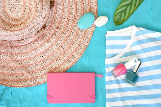 Vrouwelijke handen met zomerse nagellak in koraal en fuchsia tinten