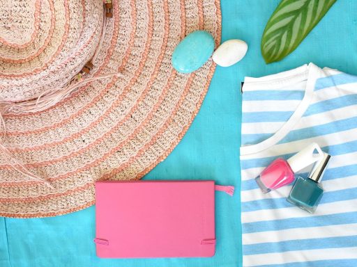 Vrouwelijke handen met zomerse nagellak in koraal en fuchsia tinten