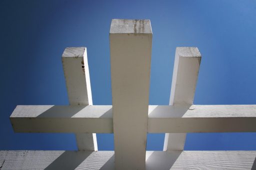 Een moderne aluminium overkapping in een strakke tuin met loungestoelen eronder