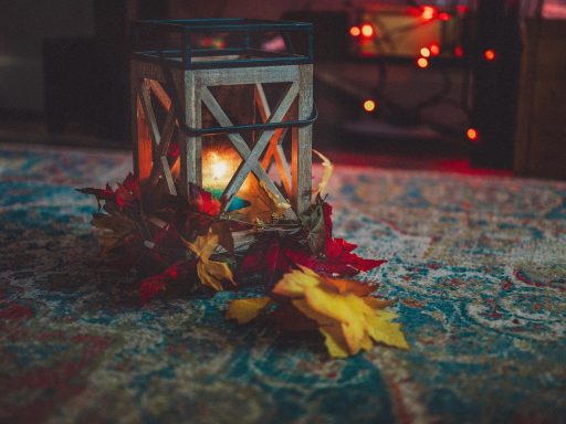 Gezellige Scandinavische woonkamer met kaarsen, een wollen plaid en warm lampicht als voorbeeld van een hygge interieur