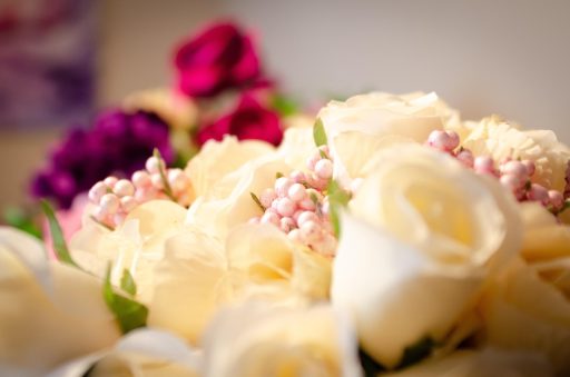 Zelfgemaakt bloemstuk op een bruiloftstafel met rozen en eucalyptus