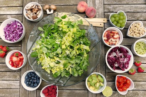 Diverse gefermenteerde voedingsmiddelen zoals kimchi, zuurkool en kefir in kommetjes op een houten tafel