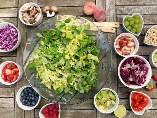 Diverse gefermenteerde voedingsmiddelen zoals kimchi, zuurkool en kefir in kommetjes op een houten tafel