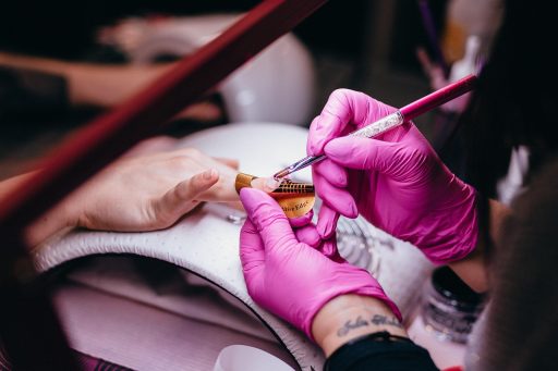 Vrouw die haar nagels laat behandelen in een nagelstudio
